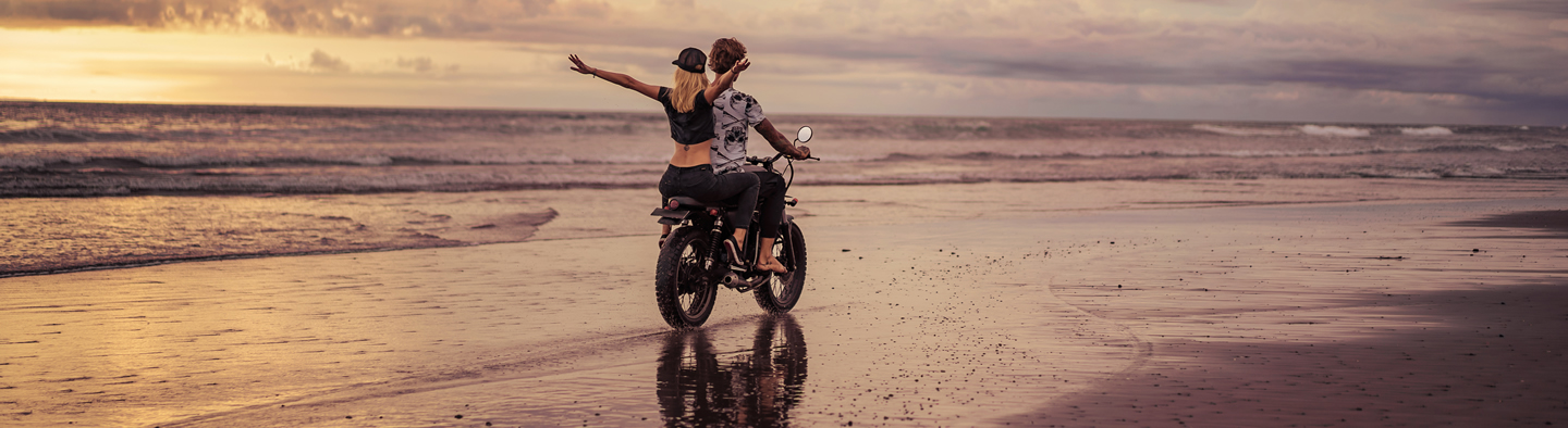 FECA - Loans - Motorcycle back-view-of-couple-riding-motorcycle-on-sandy-oce
